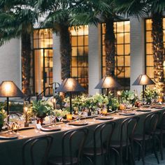 a long table is set up with several lamps and place settings for an elegant dinner