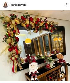 a christmas wreath is hanging on the wall next to a mirror and wine bottle holder