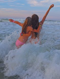 two girls in the ocean playing with a frisbee