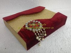 a red and gold clutch with pearls on it