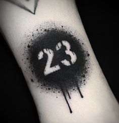 a black and white ink splattered wrist with the number 23 on it