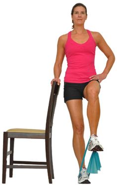 a woman standing next to a chair with her leg up on the back of it