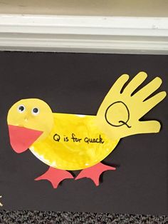 a paper cut out of a yellow bird with the words q is for quack on it