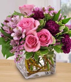 a glass vase filled with pink and purple flowers