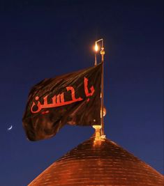 a flag on top of a building with the moon in the background