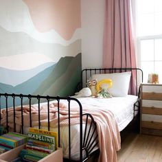 a bed room with a neatly made bed and a painting on the wall behind it