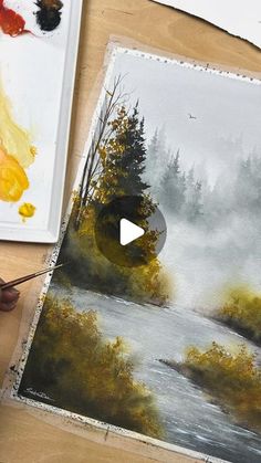 someone is painting a landscape with watercolors