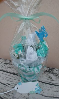 a bouquet of flowers wrapped in plastic and sitting on a wooden table next to a tag