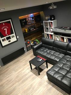 a living room with black leather furniture and bookshelves