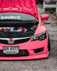 the hood of a pink honda car with an engine in it's trunk compartment