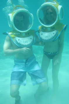 two people wearing scuba gear in the water with their hands on each other's hips