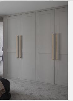 an image of a bedroom setting with white and gold accents on the doors, drawers, and headboard