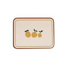 two oranges on a white and brown placemat with an orange design in the center