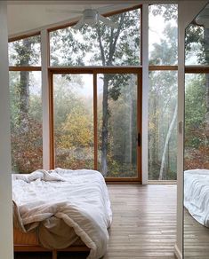 a bed sitting in a bedroom next to large windows