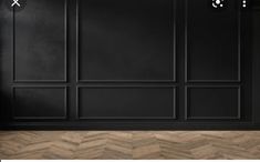 an empty room with black walls and wood flooring is seen in this image, there are