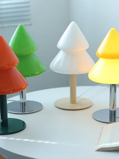 three different colored lamps on top of a white table