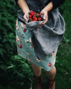 a woman holding a bag full of strawberries