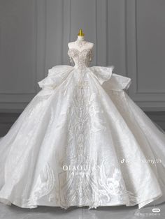 a white wedding dress on display in front of a wall