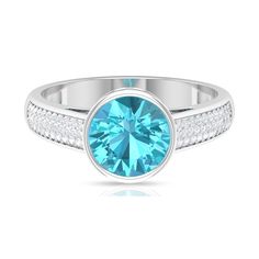 a blue ring with diamonds on the sides and an oval cut stone in the center