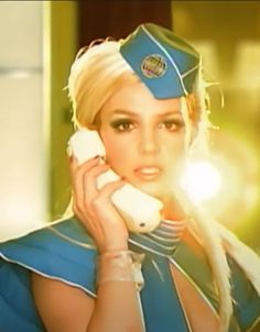 a woman dressed in blue talking on a cell phone