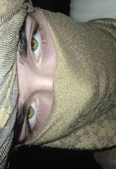 a close up of a person wearing a towel on their head and covering his face