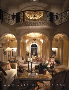 a living room filled with lots of furniture next to a stair case in a house