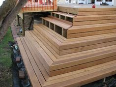 a wooden deck is being built on the side of a house with stairs leading up to it