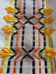 an assortment of decorative ribbons on a tablecloth with orange, green and brown stripes