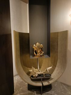 an artistic display in the corner of a room with gold and black decorations on it