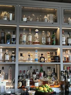 an assortment of liquor bottles and glasses on shelves