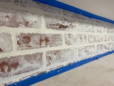 a brick wall that has been painted blue and white