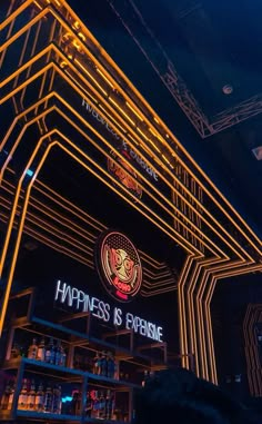 the interior of a bar that is lit up with neon lights and an advertisement for happiness is expensive