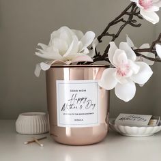 a pink candle sitting on top of a table next to flowers