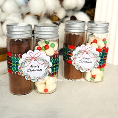 three jars filled with christmas candy sitting on top of a table