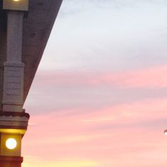 an airplane is flying in the sky at dusk with its landing gear still down and lights on