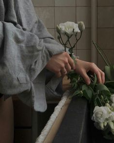 a person is arranging flowers on a table