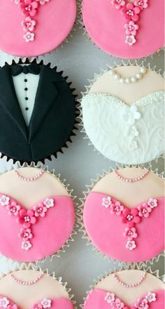 four decorated cupcakes in the shape of heart and tuxedo on display