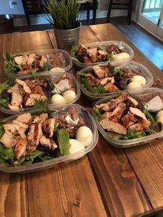 several plastic containers filled with food on top of a wooden table