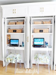 two computer screens sitting on top of a white bookcase