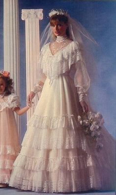 two women in wedding dresses standing next to each other