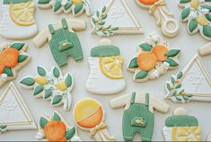 decorated cookies are arranged in the shape of baby's booties and oranges