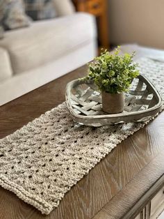 a potted plant sitting on top of a wooden table next to a white couch