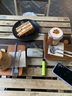 there is a piece of cake on the table next to a drink and cell phone