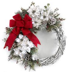 a christmas wreath with white flowers and red ribbon