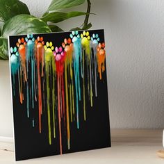 an abstract painting with multicolored paint splattered on black art board print