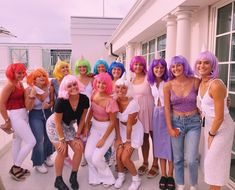 a group of young women standing next to each other in front of a white building