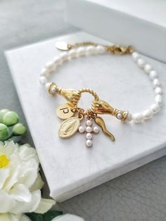 This is an Elegant vintage style bracelet featuring Italian Horn charm, Virgin Mary, Cross, and personalized with initial letter.  You can choose your favourite combination of lucky charms Gold filled metal with Natural rice pearls. Makes a beautiful and thoughtful gift for your loved ones. All our items are custom made, it takes 3-5 days to get your order prepared.  The delivery date will depend on your location.  * USA - 2 - 4 weeks * Canada - 2 - 5 weeks * Europe - 2-3 weeks * Other - 2 - 4 weeks Please read our frequently asked questions FAQ to find out more Vintage White Pearl Bracelet Gift, Vintage Gold Rosary Bracelet Gift, Vintage Gold Rosary Bracelet As A Gift, Vintage Gold Rosary Bracelet For Gift, Pearl Jewelry With Dangling Charms As Gift, Vintage Pearl Charm Bracelet For Gift, Vintage Pearl Charm Bracelet Gift, Italian Charms, Rice Pearls