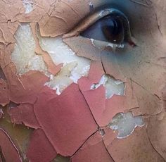 a woman's face with torn up paint on it