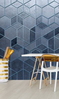 a white table and chair in front of a wall with blue hexagonal tiles