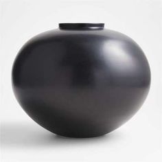 a black vase sitting on top of a white table